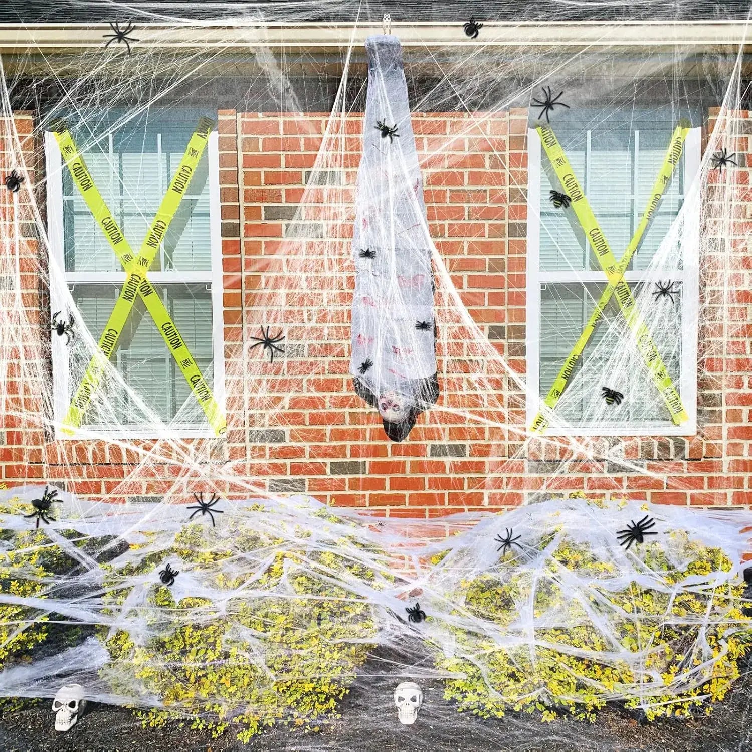 una decoración colgante para fiesta de Halloween que presenta una araña de tela gris con detalles negros suspendida en telarañas blancas semielásticas de máxima elasticidad