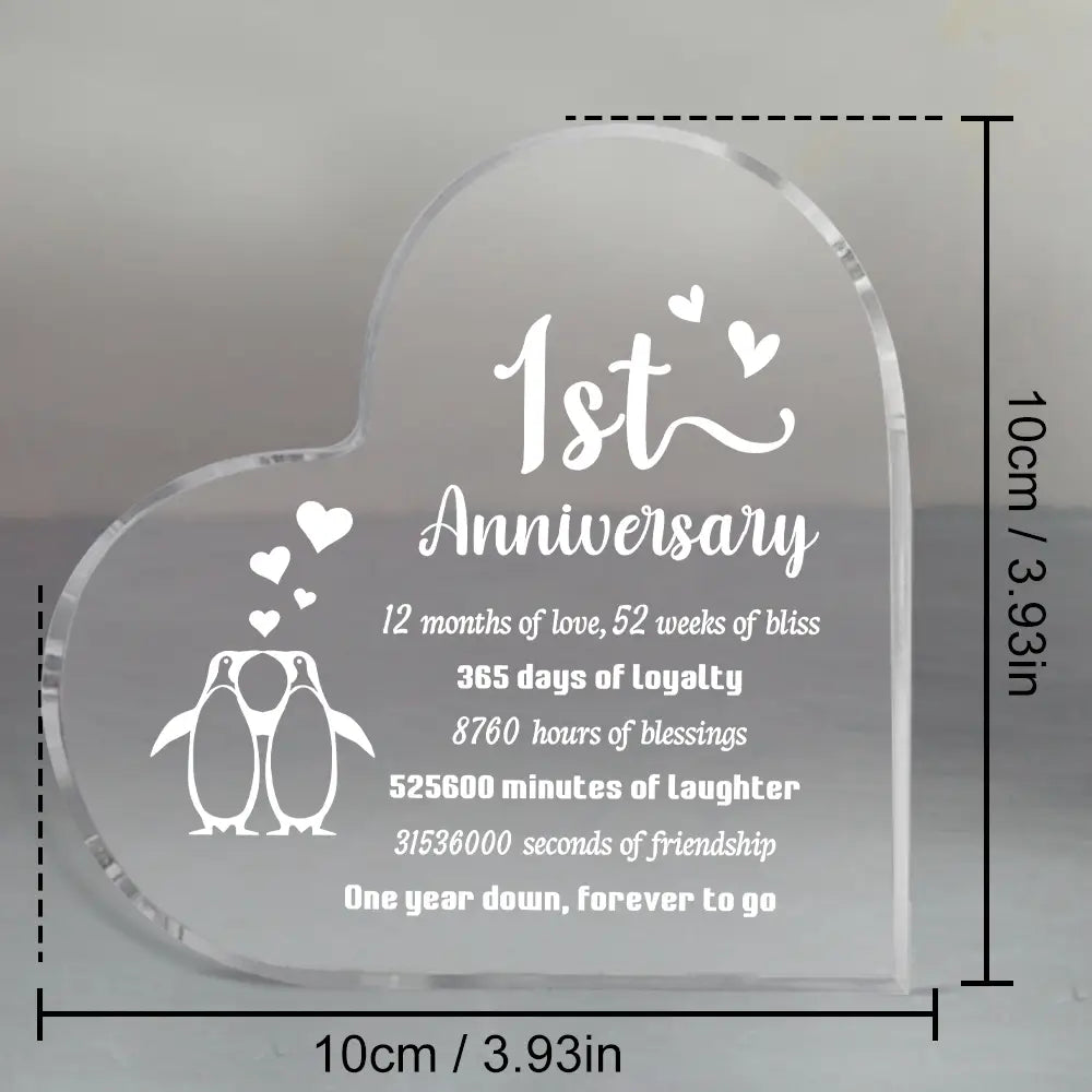 Plaque acrylique de pingouin en forme de cœur pour anniversaire d’un an, en acrylique transparent, avec texte blanc gravé et motif de pingouin.