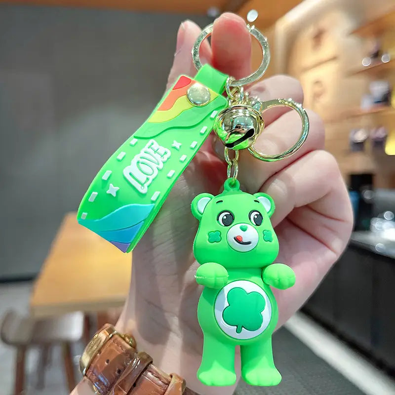 Bright green silicone Care Bears cartoon keychain featuring a clover emblem and a rainbow-colored strap with the word love for use as a backpack pendant.
