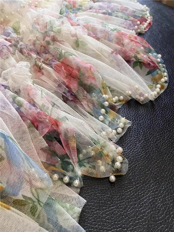 Tejido de tul translúcido delicado con flores, falda fairycore de tul floral con ribete de perlas a lo largo del borde.