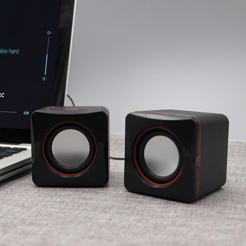Black cube-shaped USB computer speakers with red accent rings around circular drivers and LED stereo audio for desktop PC use.