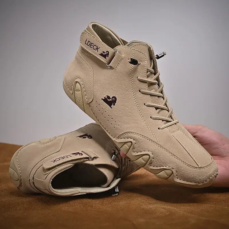 Men high top leather casual sneakers in beige suede with black logo accents and a distinctive wavy design on the side.