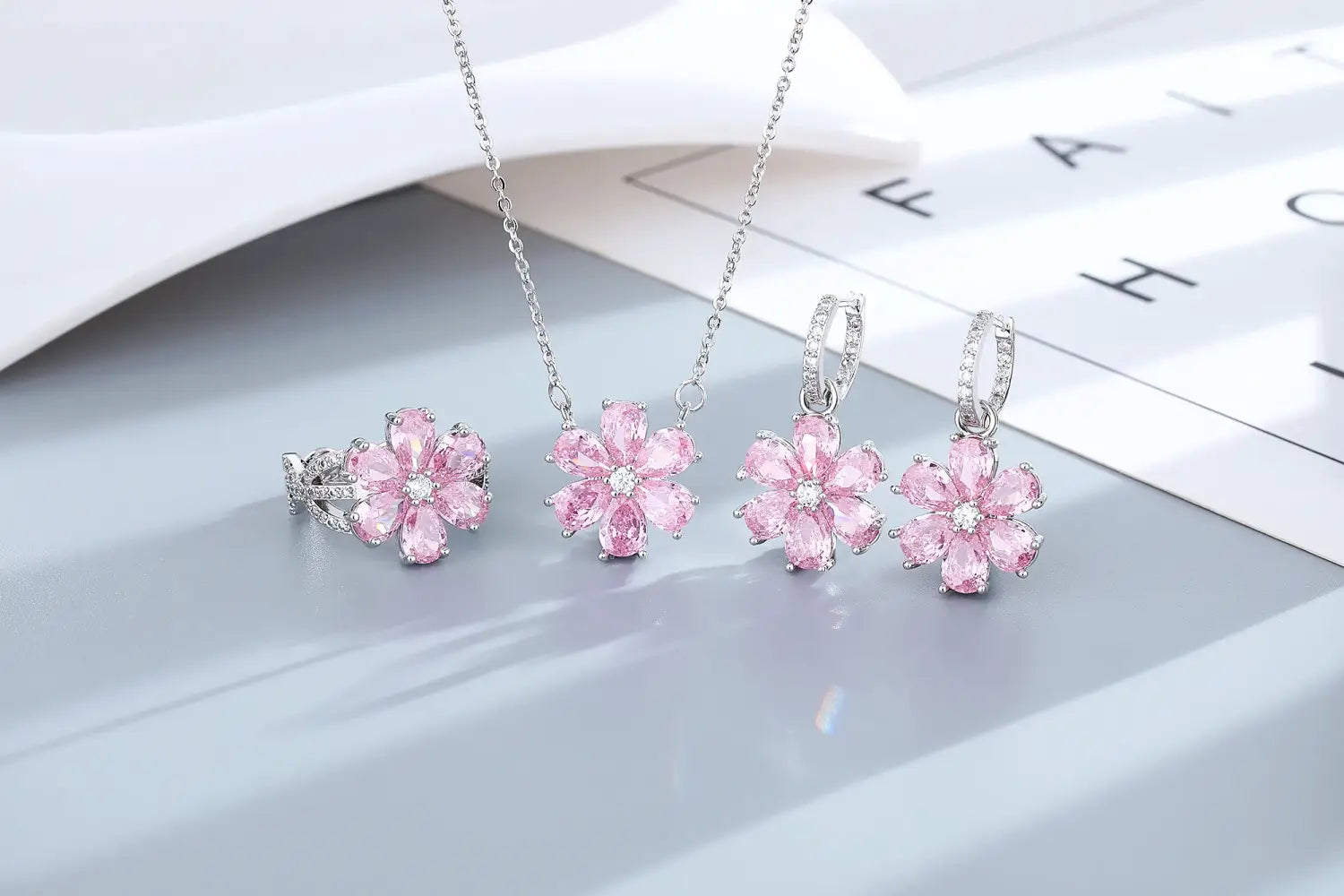 Schmuckset „Silber Pink Kirschblüte“ mit einem designinspirierten Motiv der pinkfarbenen Kirschblüte mit silberfarbenen Metallarbeiten und funkelnden Edelsteinen