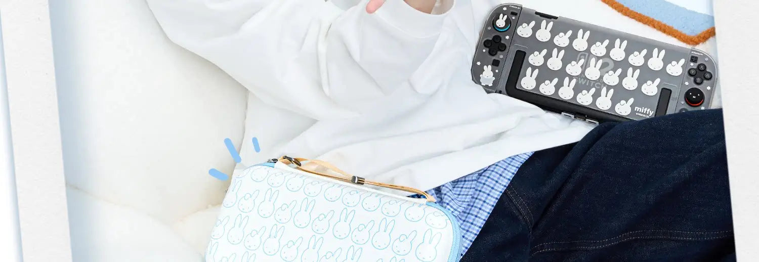 Consola Nintendo Switch gris con calcomanías de carita de conejito blancas y funda azul claro a juego con el mismo patrón, mostrada con protector de pantalla de vidrio templado para Miffy Switch.