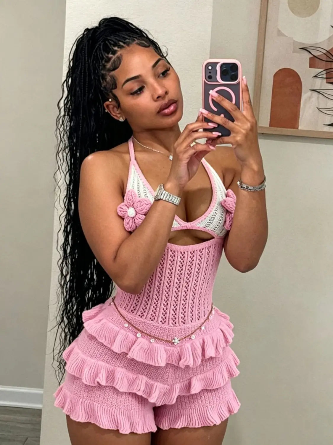 pink knitted two-piece summer playsuit featuring a halter top with floral embellishments and ruffled shorts
