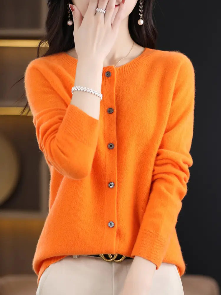 Vibrant orange merino wool cardigan women cashmere knit sweater with long sleeves dark buttons and a round neckline.