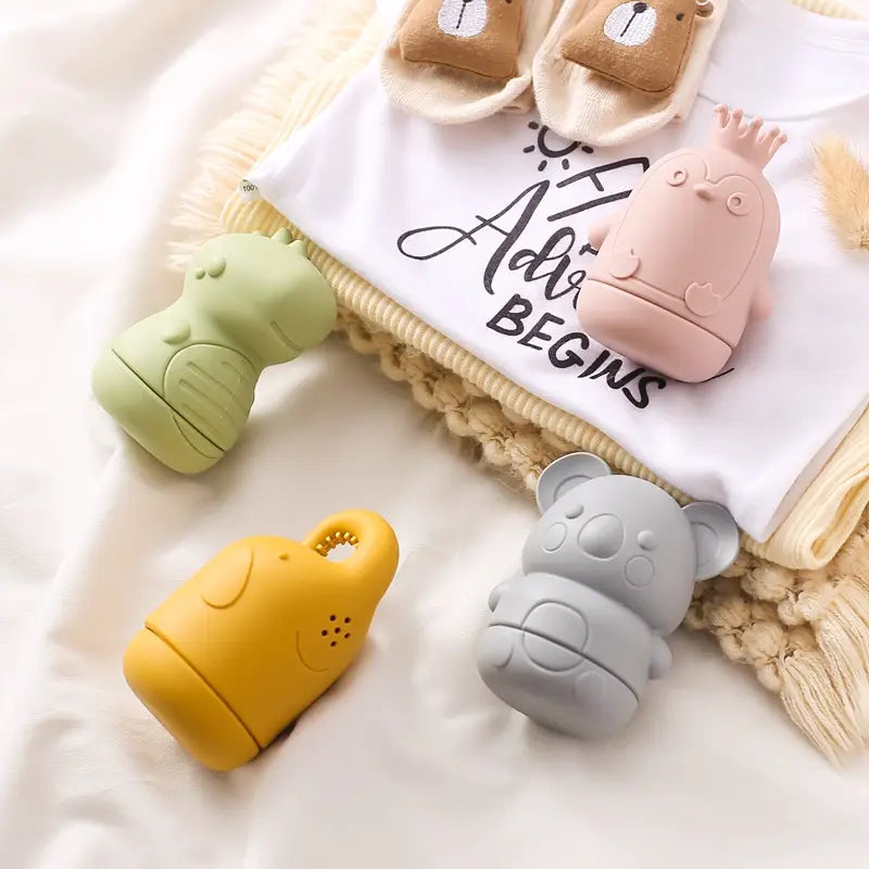 Pastellrosa, mit einer Krone verzierte Küken-förmige Silikon-Wärmer für Babyflaschen, als Silikon-Koala-Baby-Badesprinkler-Spielzeug gestaltet.