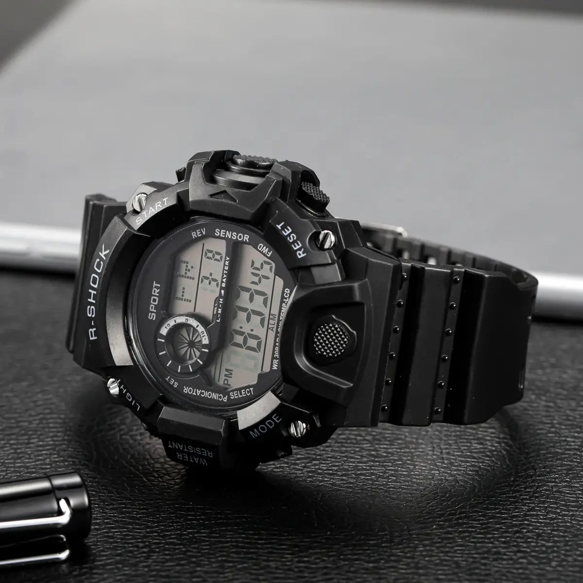 Schwarze R-Shock digitale Sportuhr für Herren mit robustem, texturiertem Gehäuse und Riemen, mit großem Zifferblatt und wasserdichtem Merkmal.