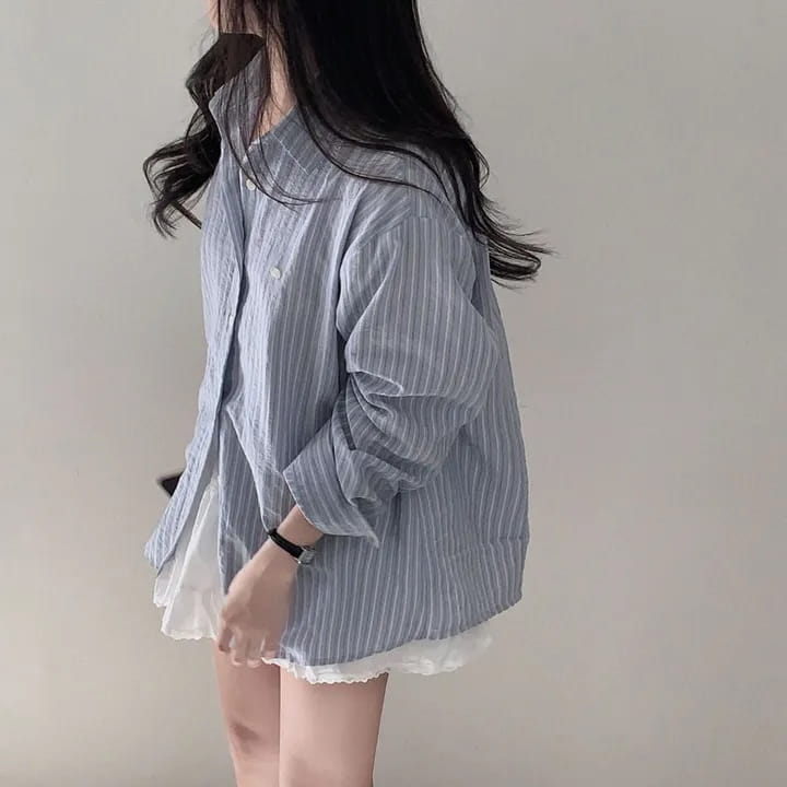 Striped long sleeve button down shirt in light blue and white with a subtle textured fabric and standard thickness for a versatile style.