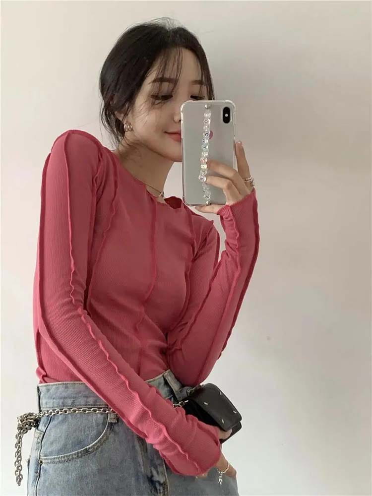Ein hellblauer gerippter Longsleeve-Top für Damen mit schlankem Casual-Fit, leicht taillierter Silhouette und gerafften Details entlang der Ärmel.