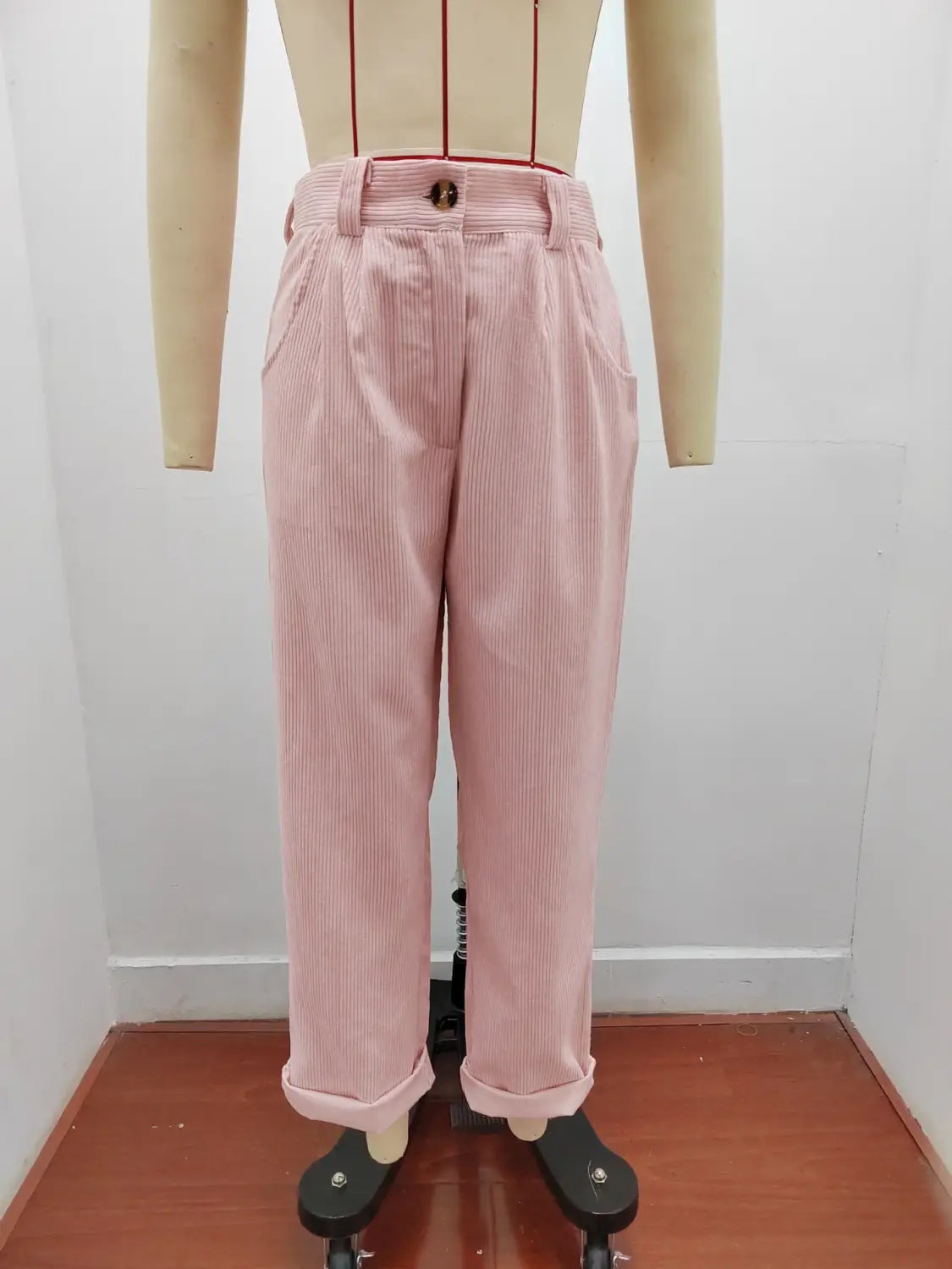 Pantalon en velours côtelé rose à fines rayures, taille haute ample, fermeture par boutons et bas retroussés
