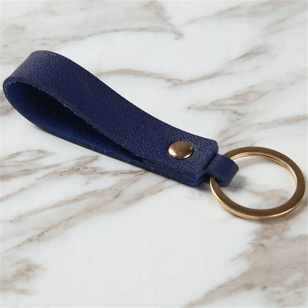 Navy blue pu leather keychain with gold-toned metal keyring and button fastening for secure key organization.