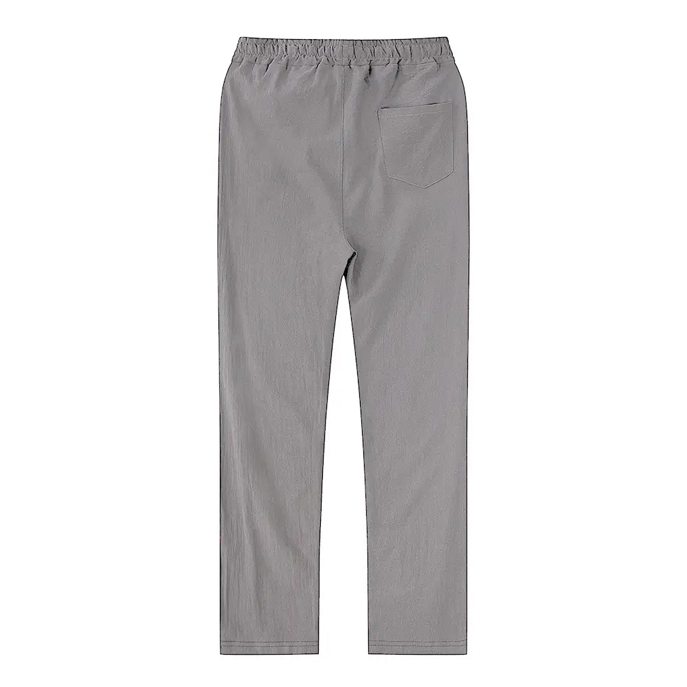 The back side of gray cotton linen trousers featuring an elastic waist and a single back pocket designed for breathable casual wear.