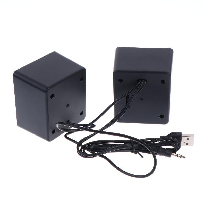 Haut-parleurs de bureau mini USB en forme de cube noirs, finition mate, et câble audio noir fourni pour une utilisation avec l’audio stéréo sur ordinateur