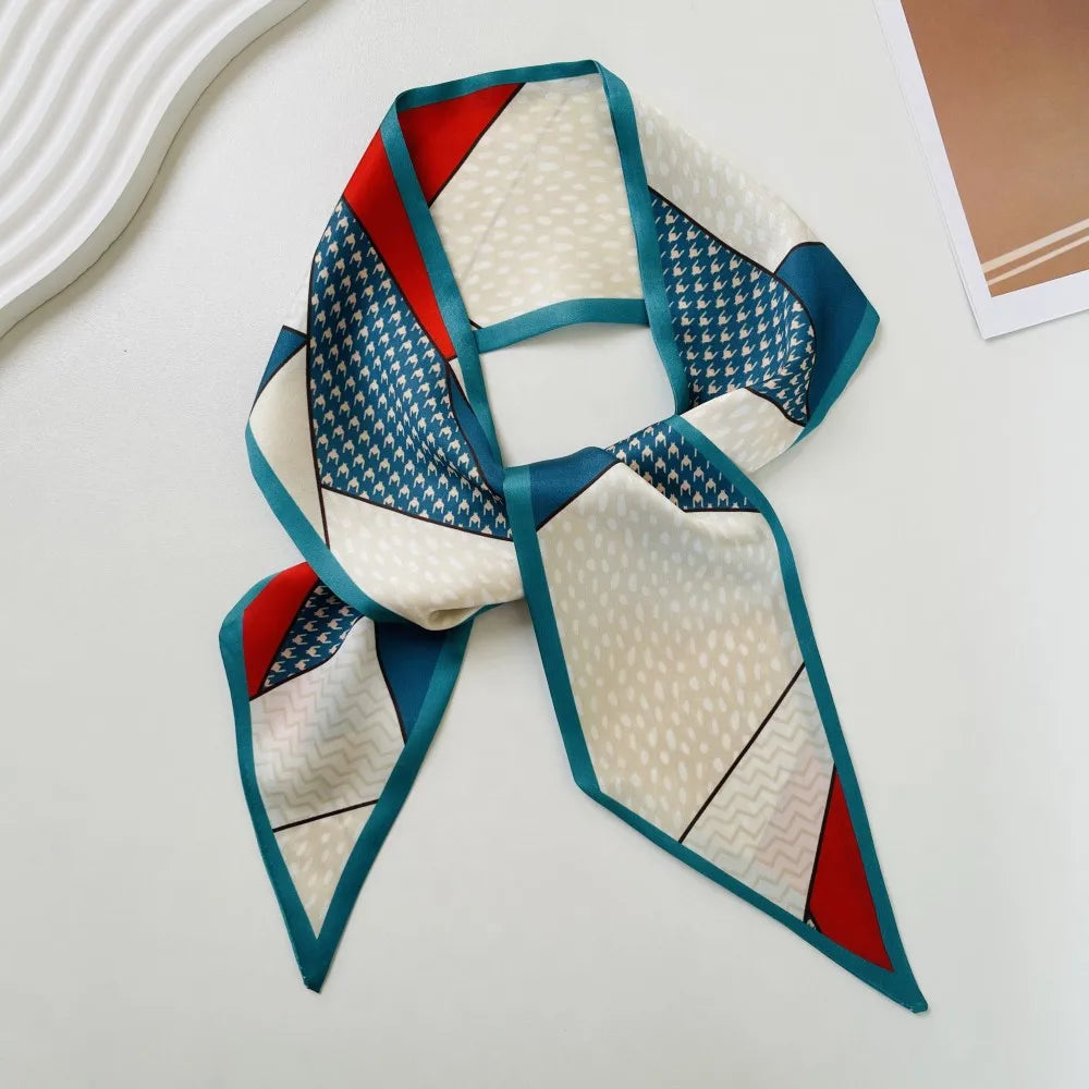 Pañuelo de seda sofisticado con patrón geométrico de pata de gallo en crema, verde azulado y rojo, diseñado como una banda de escote cuadrado.