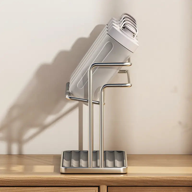stainless steel two-tier mug and cup storage rack with a stainless steel stand holding a stack of white plastic water bottles.