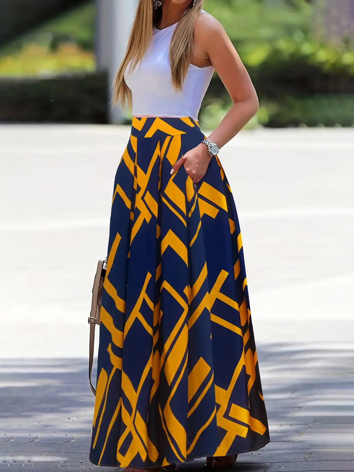 Pleated high waist maxi skirt featuring a flowing silhouette in navy blue and vibrant yellow geometric patterns crafted from lightweight fabric.