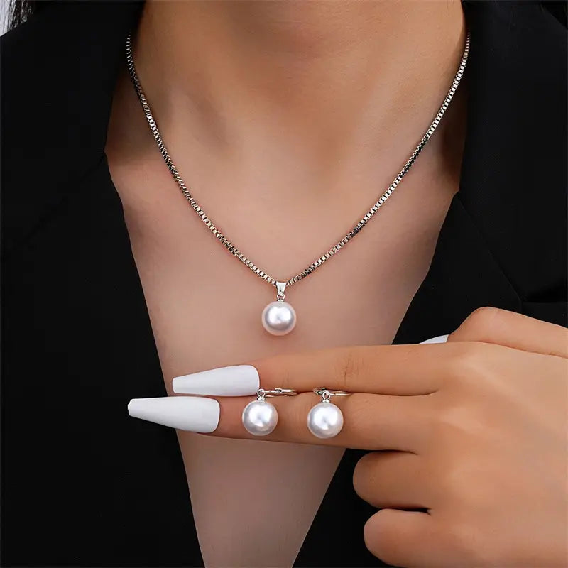 Pearl jewelry set gold necklace and earrings featuring a delicate silver chain necklace with a single round white pearl pendant and matching pearl stud earrings.