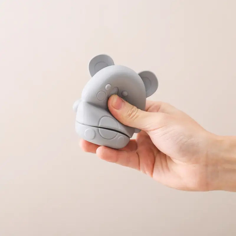 Graues Silikon-Koala-Baby-Badesprinkler-Spielzeug mit abgerundeten Ohren und kreisförmigen Strukturdetails.