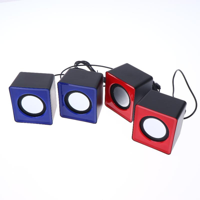 Set of four cube-shaped usb desktop speakers in vibrant blue and red with black accents and a glossy finish for stereo audio computer system use.