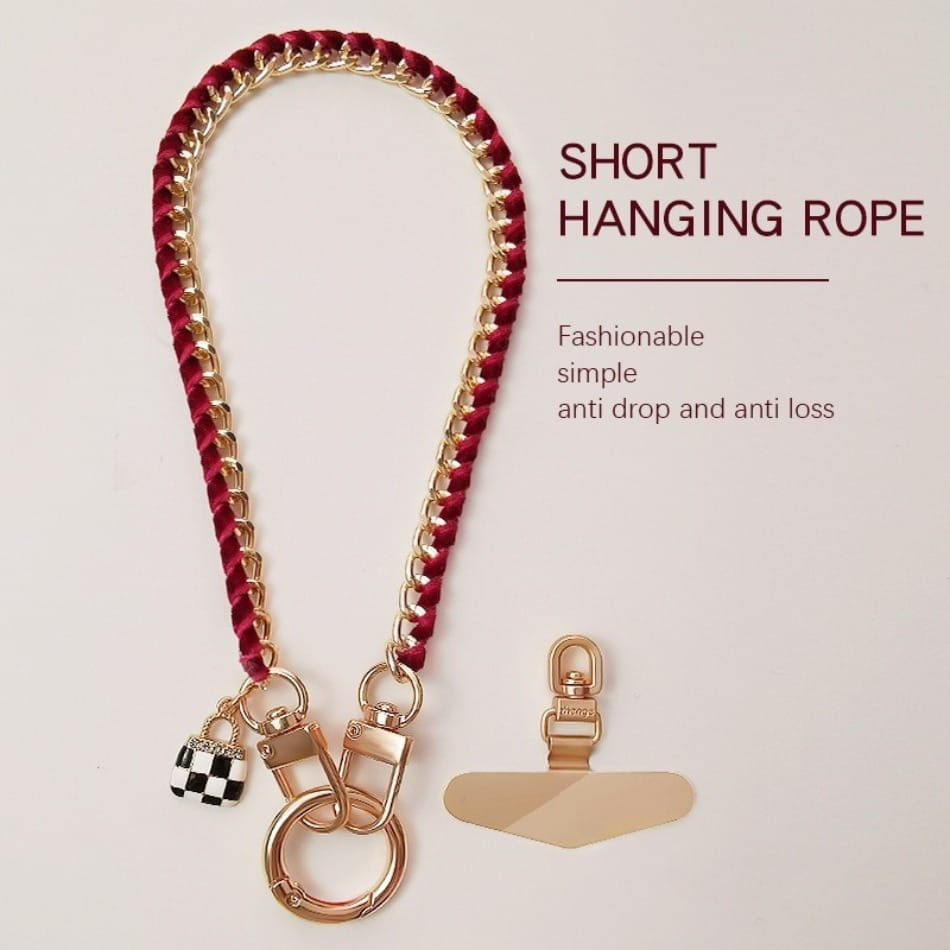 Ein stilvoller Handy-Handgelenkriemen aus goldfarbener Kette mit kurzem hängendem, geflochtenem rotem und goldfarbenem Kord-Design, mit einem karierten Anhänger und Metall-Klipsen für Anti-Lost-Verwendung.