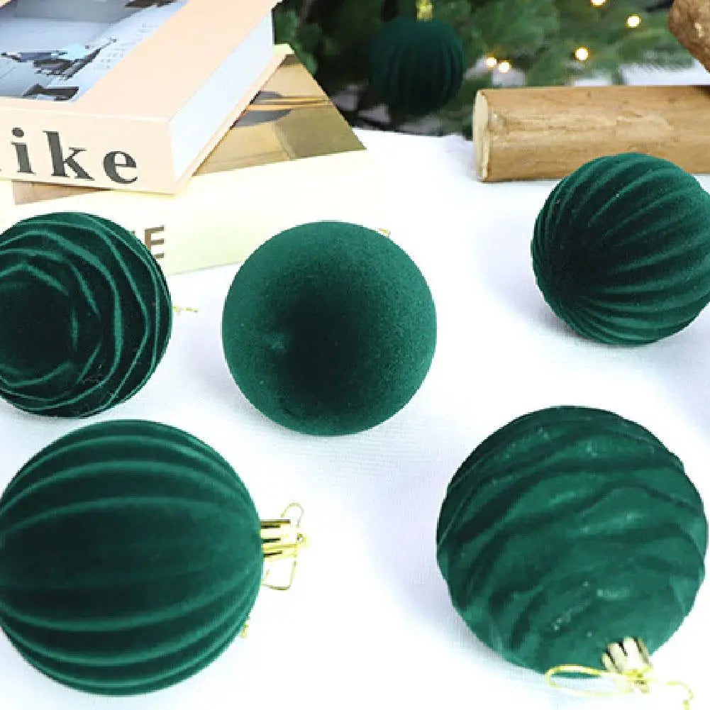 Smaragdgrüne Christbaumkugeln in Samtoptik mit gerippter Samtstruktur und goldfarbenen Aufhängeschlaufen in einer 12-teiligen Sortimentsauswahl.
