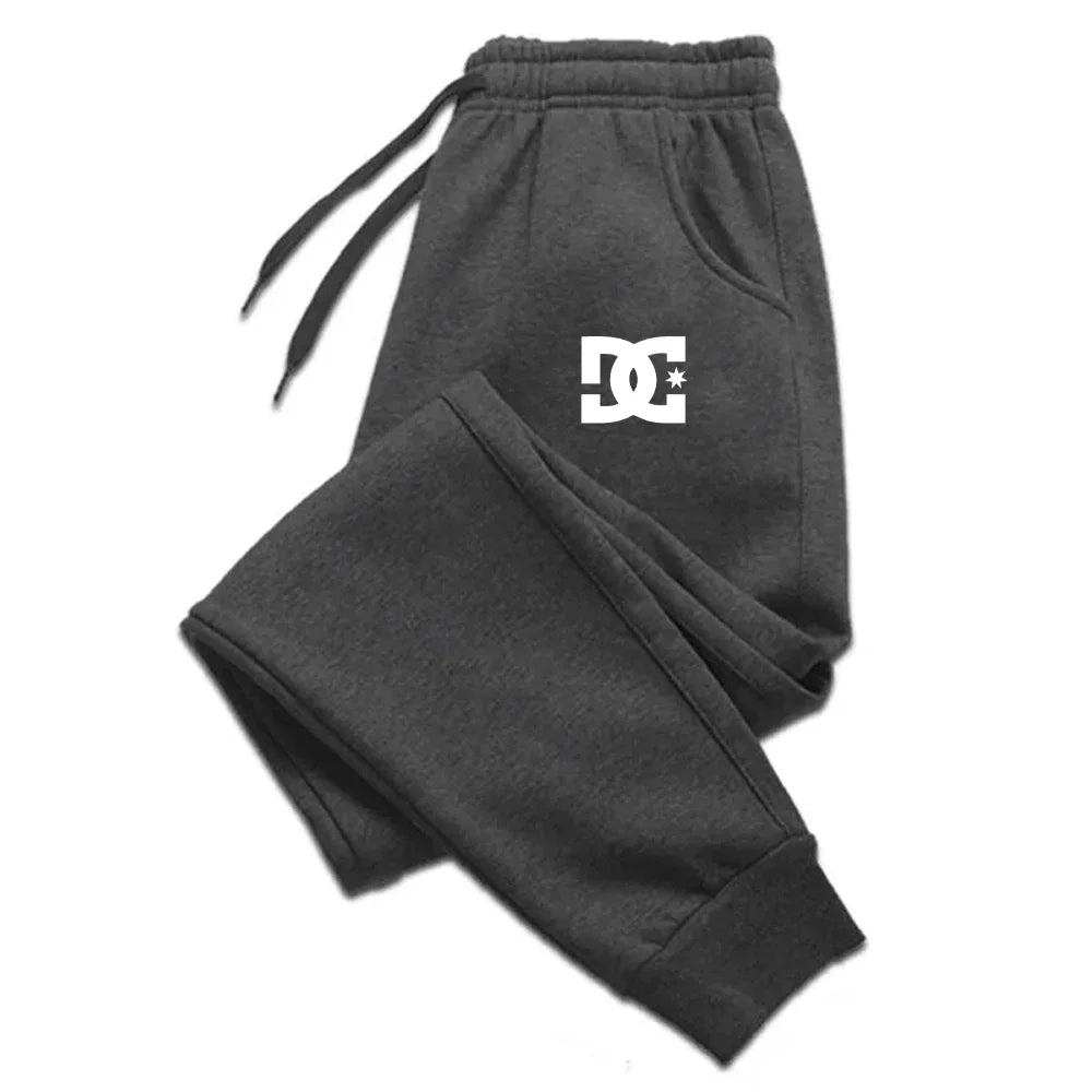 Dunkelgraue Dc Shoes Herren-Jogginghosen, legere Sweatpants, mit einem weißen Logo auf dem linken Oberschenkel.