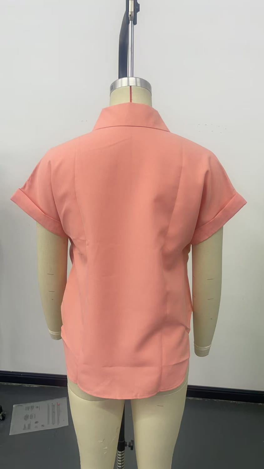 A coral-colored short sleeve button up blouse for women displayed on a mannequin highlighting the sleeve length and button detailing.