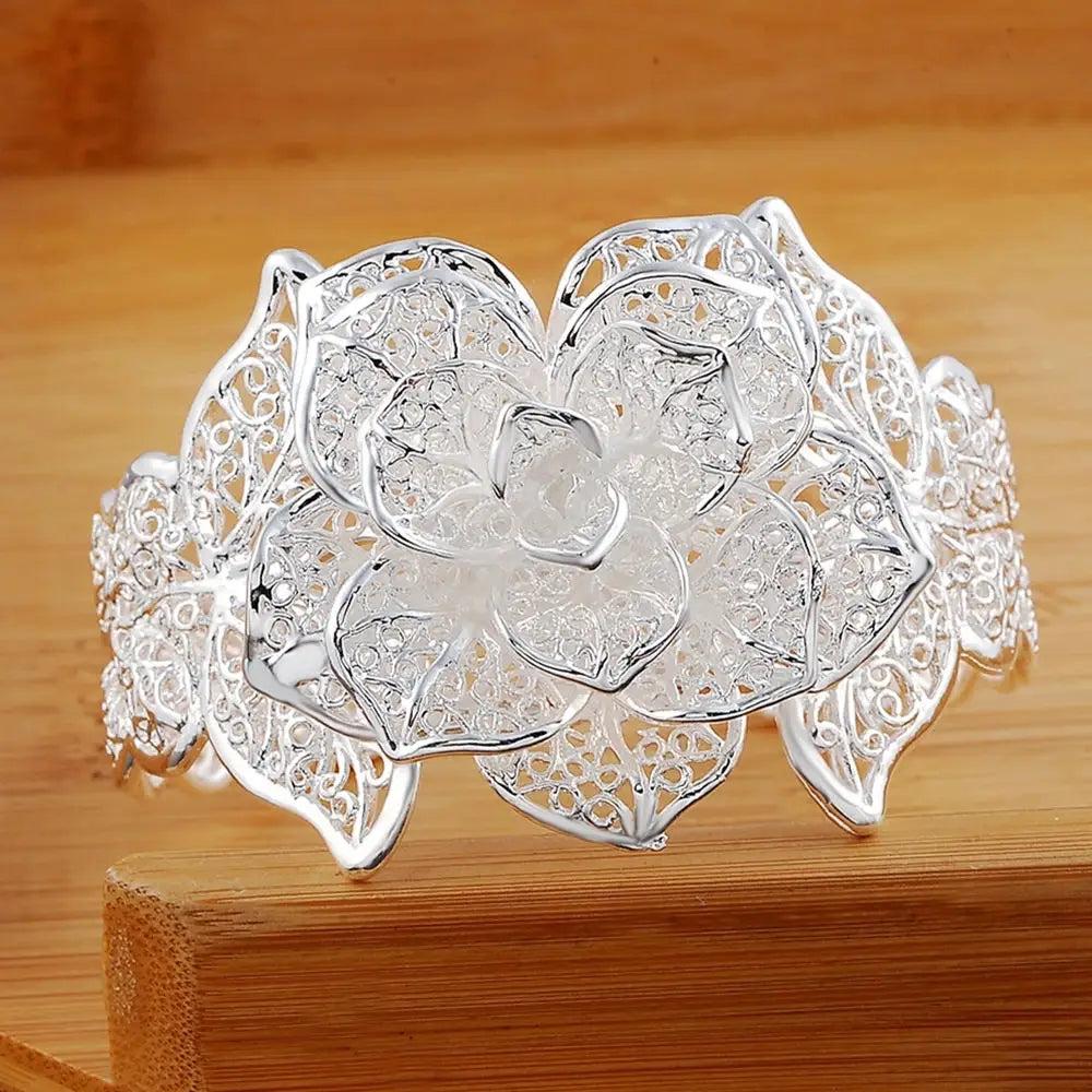 Parure de bijoux floraux en argent sterling comprenant un bracelet manchette de fleur en filigrane d’argent, avec des détails délicats de type dentelle et un motif ajouré finement ouvragé.