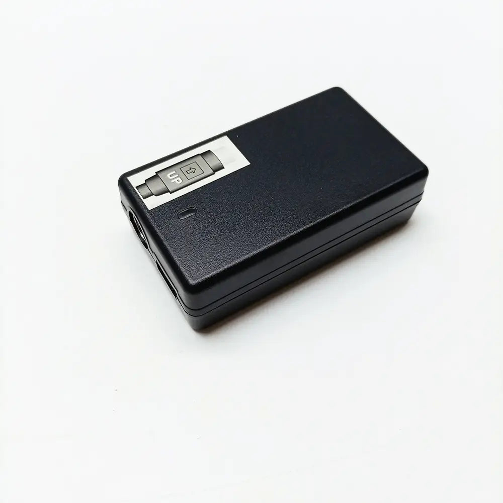 Black rectangular remote control with silver panel and directional buttons including an up label for use with power cable charger for Signal Fire fiber fusion splicer.