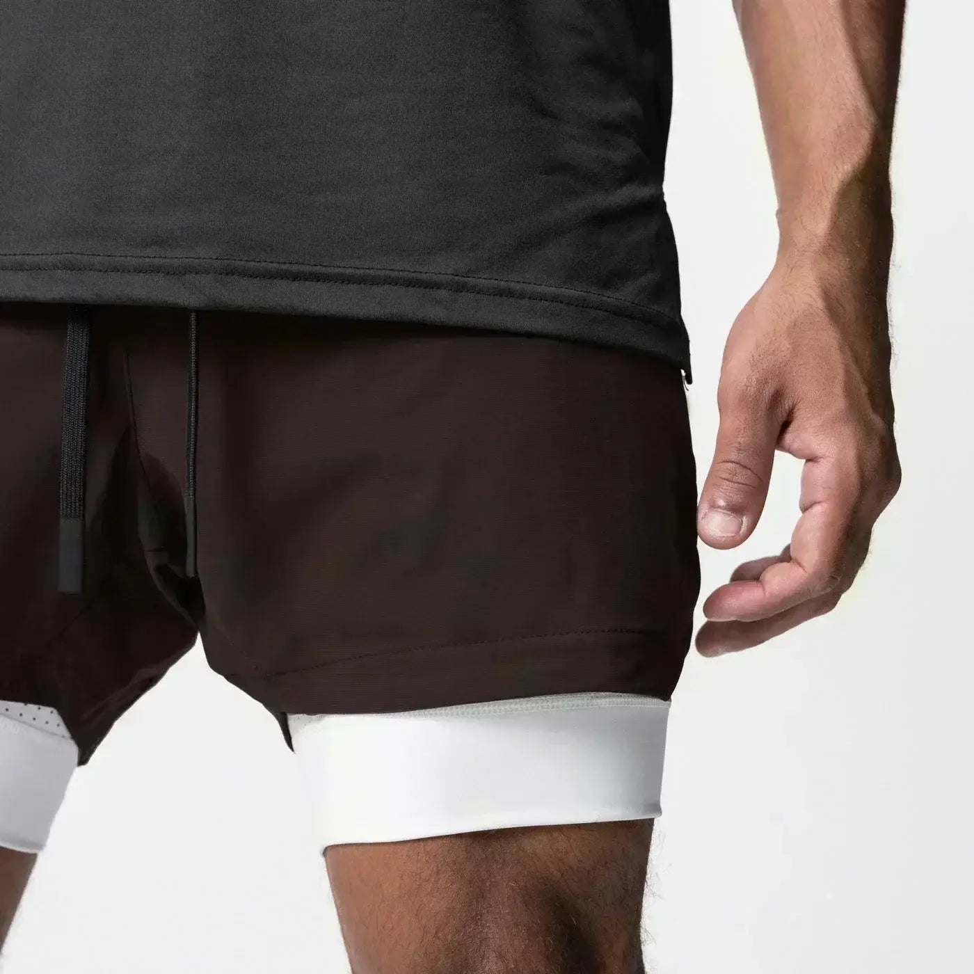 Pantalones cortos atléticos 2 en 1 para gimnasio de color marrón oscuro con capa interior blanca, cordón negro y trabilla para la toalla que ofrece soporte para los entrenamientos.