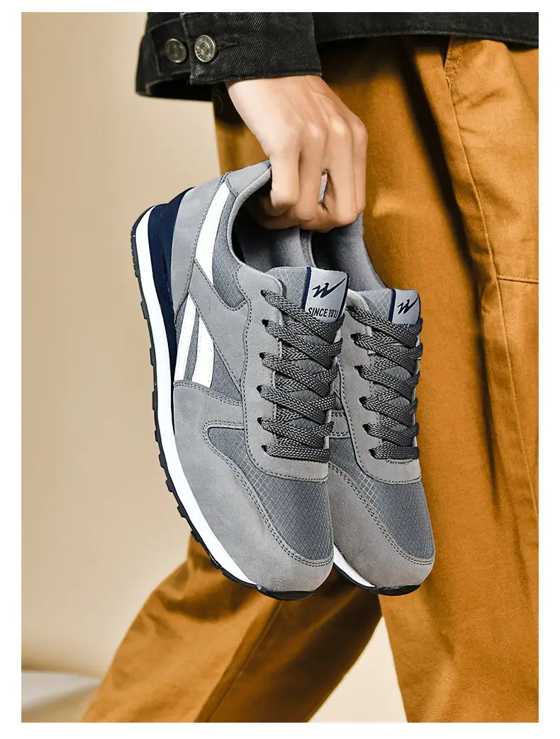 Herrenfreizeitsneaker in Grau und Weiß zum Gehen mit Obermaterial aus grauem und marineblauem Mesh sowie Wildleder, mit weißen Akzenten.