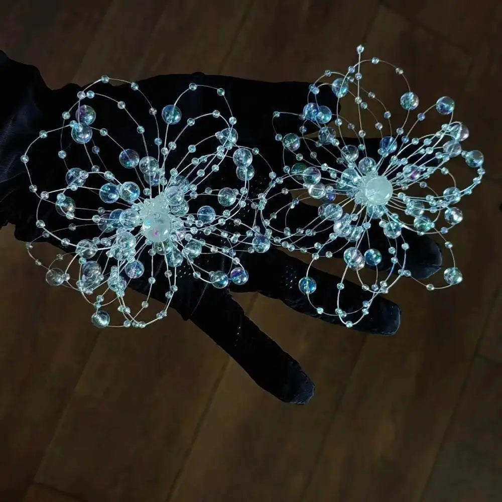 Les boucles d’oreilles pendantes en forme de goutte de fleur en cristal présentent des fleurs cristallines translucides bleu délicates et claires, avec un travail de fil complexe, idéales pour les mariages.