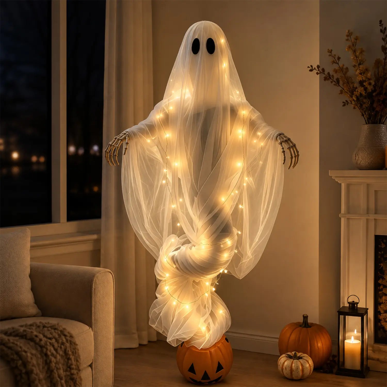 Eine leuchtende weiße Halloween-Kürbis-Geist-Lichtdekoration für den Außenbereich im Vorgarten mit schwarzen Augenöffnungen, Skelett-Händen und warmen, durch den transparenten Stoff eingewobenen Lichterketten.