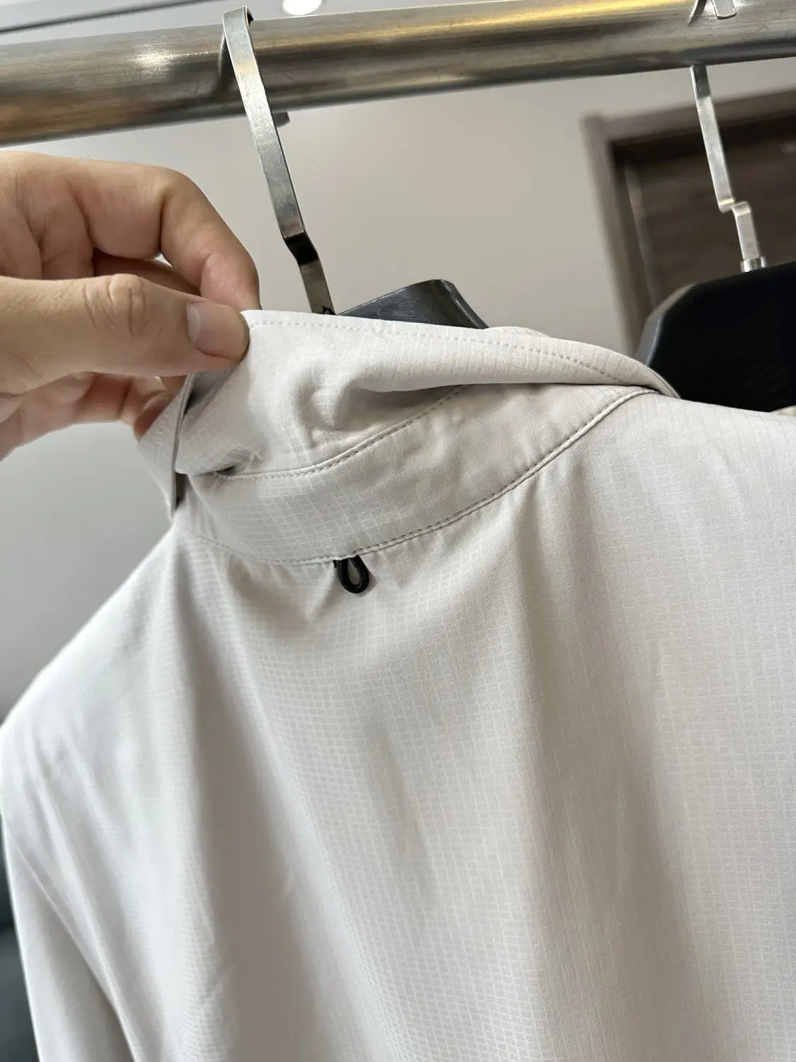 Ein markant weißes Baumwoll-Herren-Stretch-Outdoorhemd zeichnet sich durch ein subtil strukturiertes Webmuster und einen eleganten, modernen Kragen mit schnelltrocknendem Stoff aus.