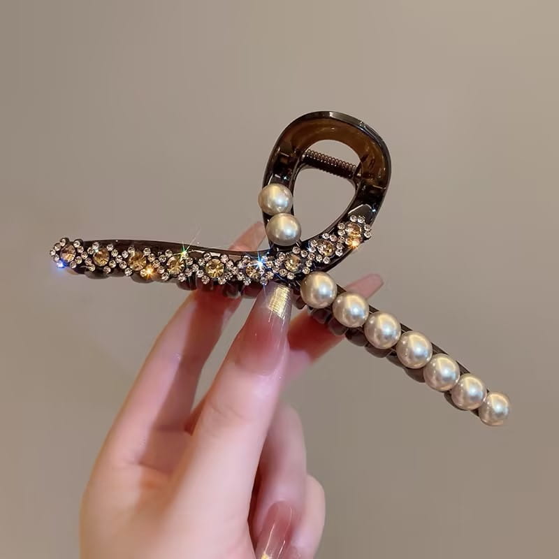 Barrette serre-cheveux en perles imitation rhinestones brun foncé, ornée de cristaux et de perles, présentant un design courbé épuré.