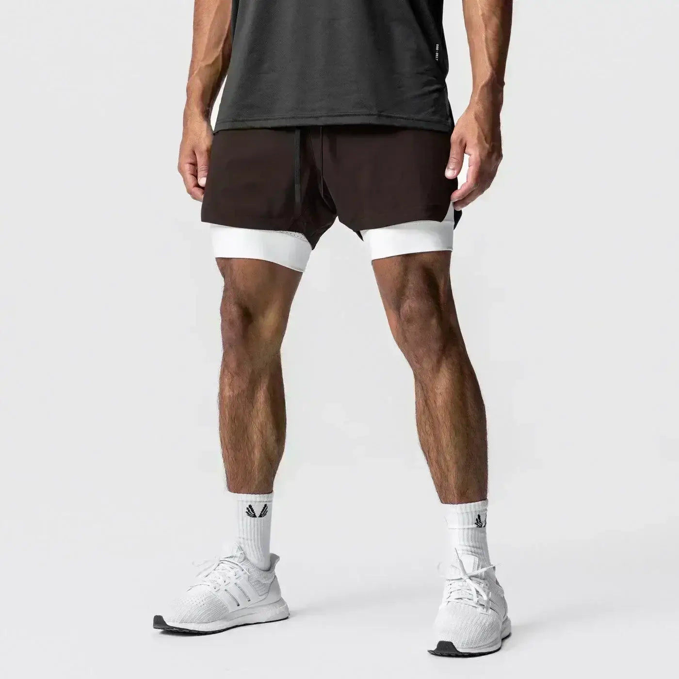 Pantalones cortos de entrenamiento de dos capas para gimnasio de hombres en negro y blanco con trabilla para la toalla y diseño moderno y elegante que ofrece soporte durante el ejercicio.