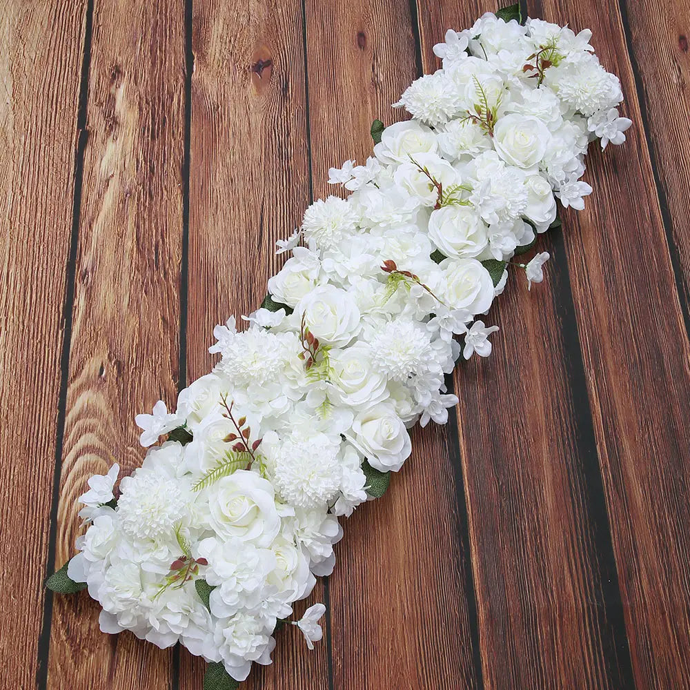 Composition de fleurs de sol pour mariage de rose blanche avec une longue guirlande florale blanche élégante, featuring des roses artificielles, des hortensias et un feuillage vert.