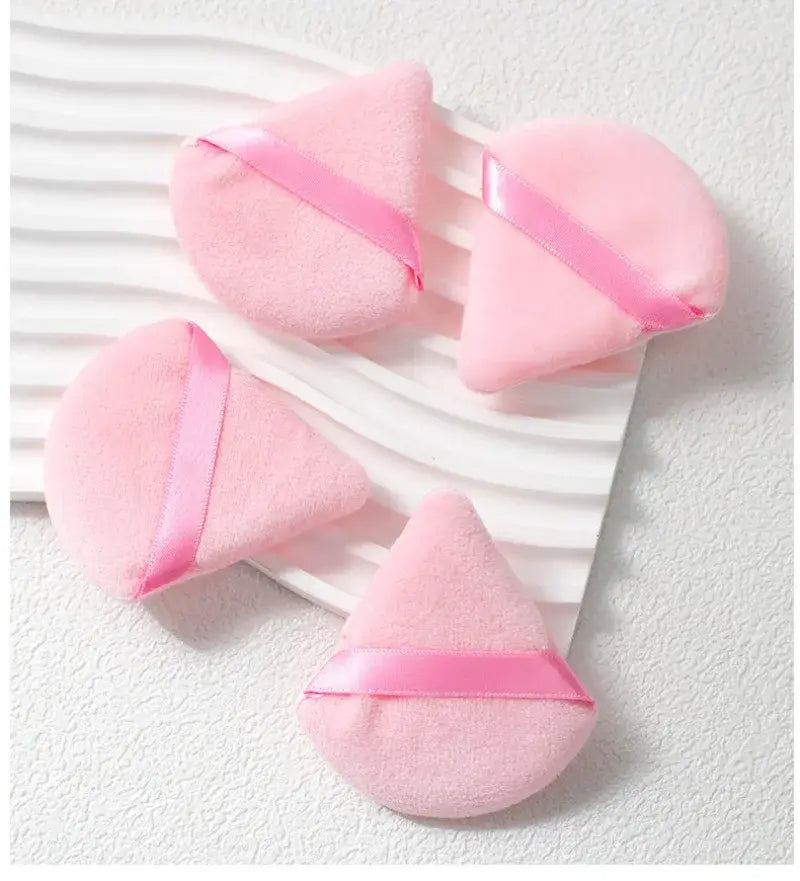 pink triangular and teardrop-shaped powder puff applicators with satin ribbon ties for precise makeup brush and eye makeup application in a 46 piece pink makeup brush and sponge set