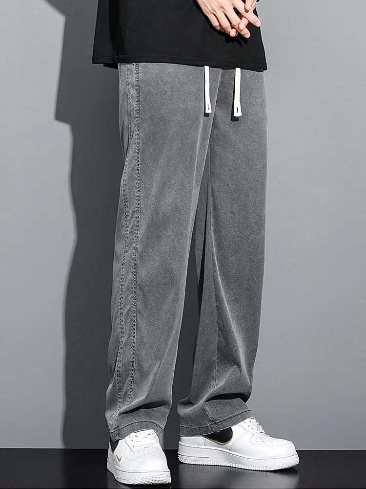 Men’s lyocell casual loose straight pants in gray denim with white drawstrings and visible stitching along the side seams.