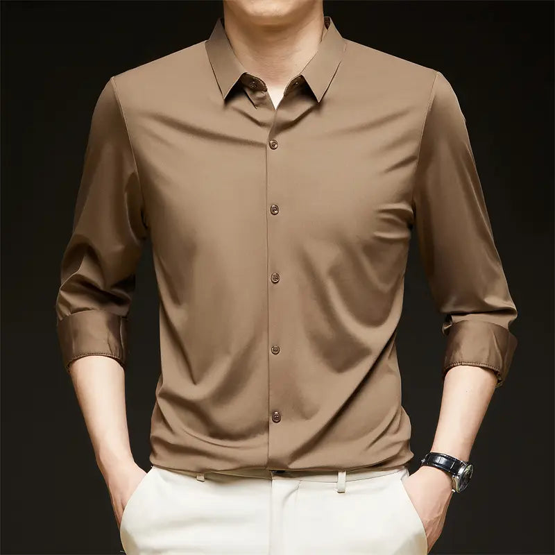 Una camisa de vestir para hombre sin arrugas color beige, elegante, con cuello clásico y parte delantera abotonada.
