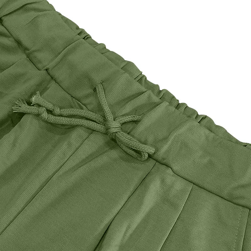 Pantalones plisados color verde oliva para hombre con cinturilla con cordón, como parte de un conjunto casual de dos piezas de camiseta y pantalones cortos