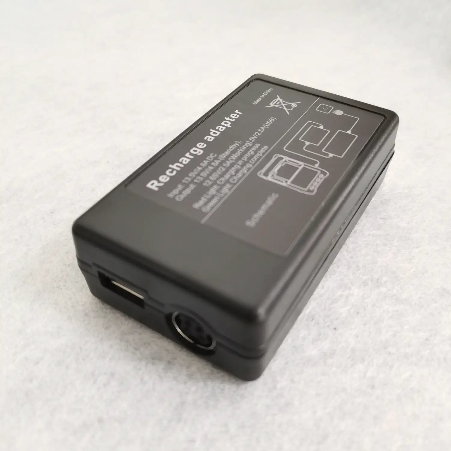 USBポートおよび背面側に印刷された仕様と図が示された円形の入力ジャックを備えた、黒色の長方形型 Signal Fire Fusion Splicer 電源チャージャーアダプター。