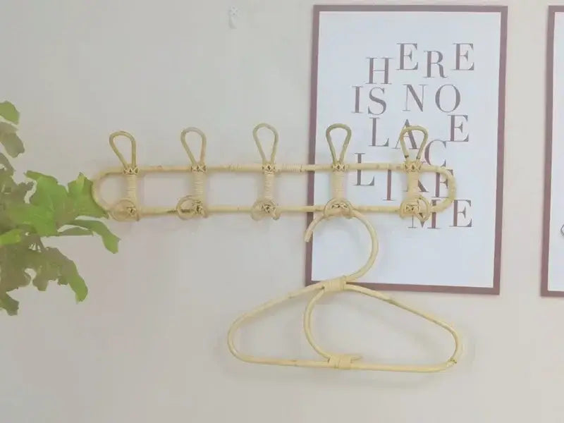 Beiger Rattan-Kinder-Wandhaken zur Aufbewahrung von Kleidung mit fünf Haken und einem hängenden Haken, an der Wand montiert.