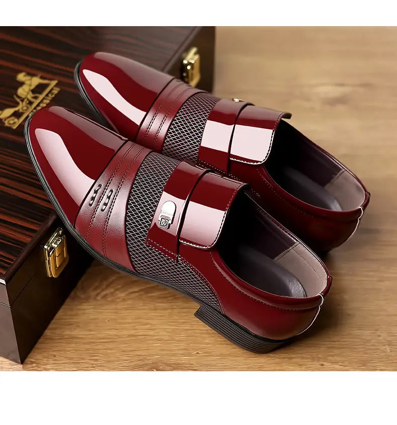 Zapatos de vestir de punta afilada de lujo para hombre en cuero burdeos pulido, con panel de malla y detalle de hebilla plateada.