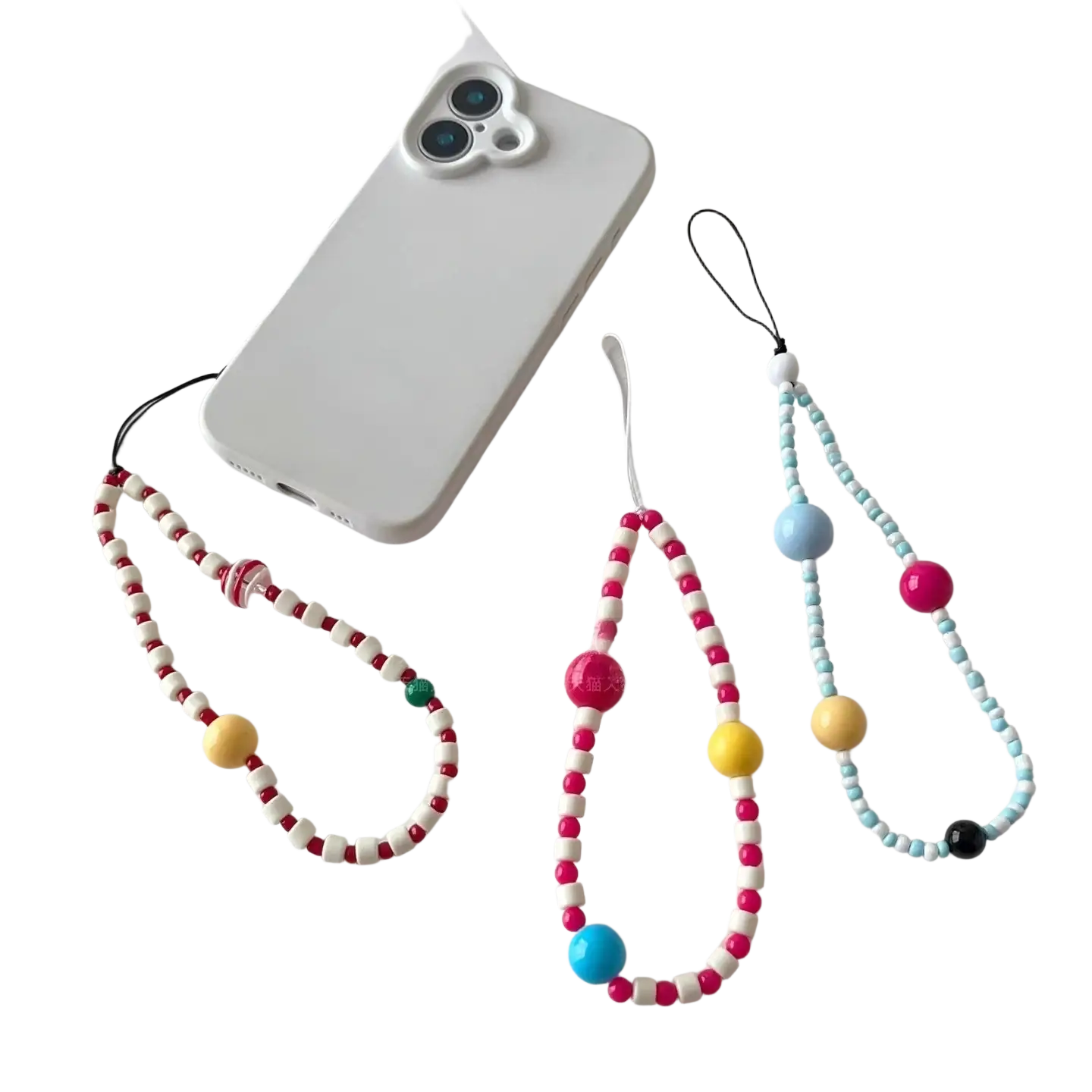 étui de téléphone blanc avec trois adorables bracelets de téléphone à perles colorées, fixés sur une surface plane