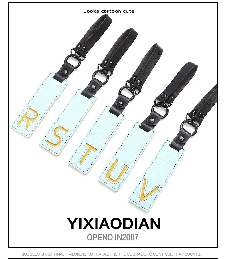 Light blue rectangular leather luggage tags with gold lettering and black straps designed as letter keychain leather alphabet pendant party gift.