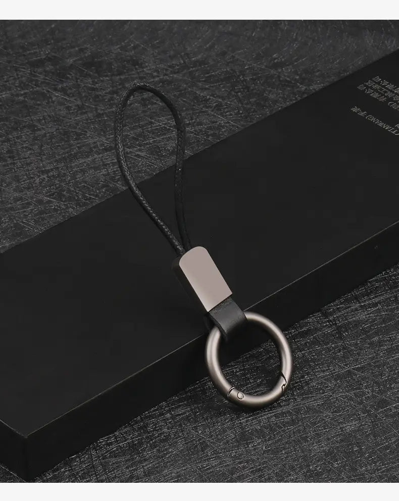 Black leather keychain lanyard featuring a matte silver metal ring and rectangular connector for car key holding.
