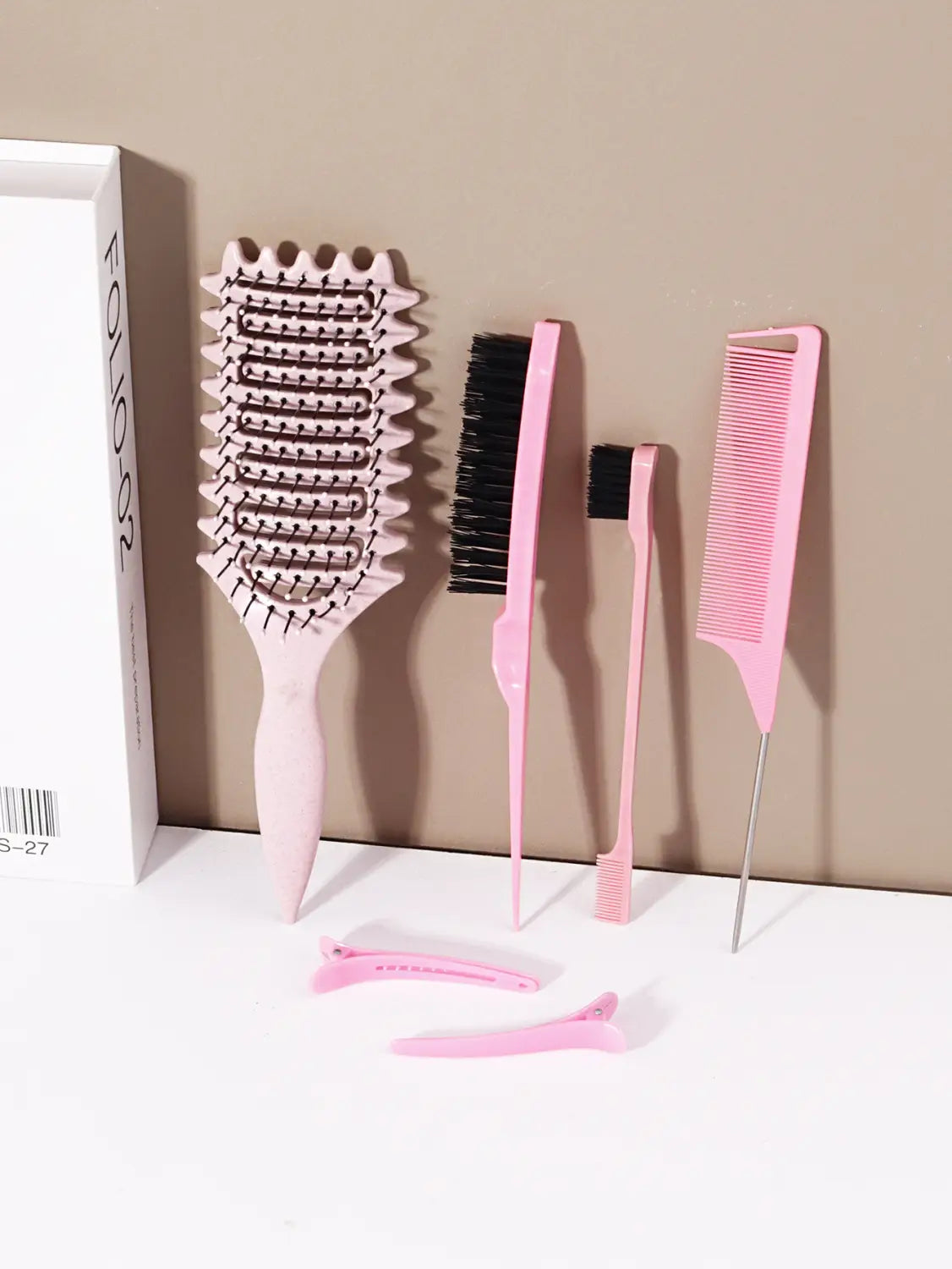 Cepillo de plástico rosa con cabeza ancha y redondeada, con hileras de cerdas negras, del conjunto de cepillos de peinado y desenredado de plástico de 6 piezas.