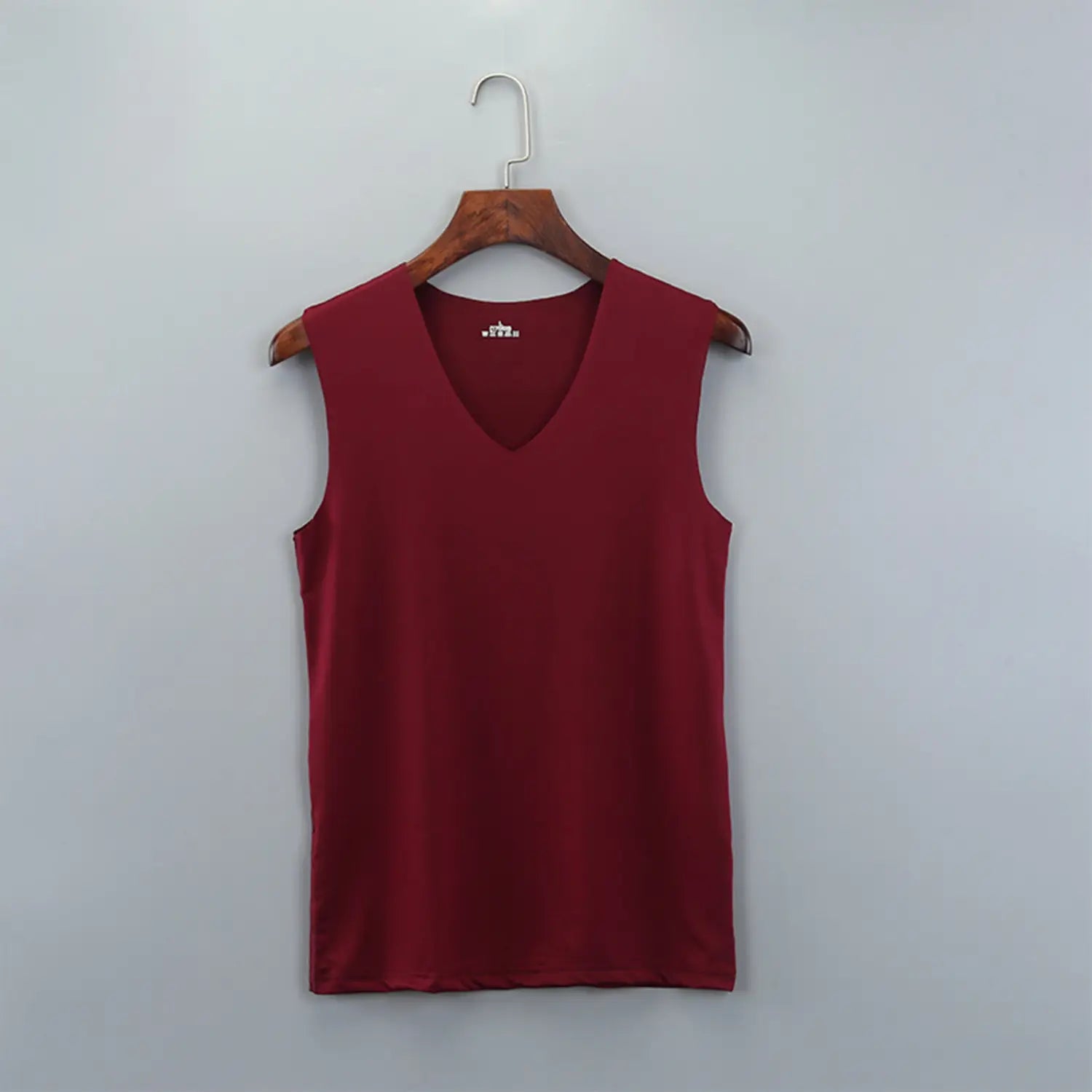 A sleek deep red men ice silk v-neck sleeveless tank top hangs neatly on a wooden hanger.